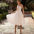 Elegant white strapless satin wedding dress with pleated midi skirt and belted waist - S (US 2) / Ivory