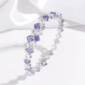 Close-up of alternating purple and white zircon crystals on a silver stainless steel cuff - Purple