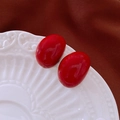 Vue détaillée de boucles d'oreilles ovales rouges brillantes sur une assiette en porcelaine blanche - Style ovale rouge (Tige en Argent - Rouge)