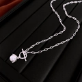 Detailed close-up of silver OT buckle necklace with a single faux pearl pendant - Silver