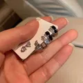 Vista detallada del set de pendientes plateados con esmalte negro y aros de circonita - Juego de Pendientes de Aro de Circonita en Negro y Plata (E5829银)