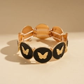 Dettaglio del bracciale elastico dorato con smalto nero e rilievi a forma di farfalla - Nero-Rilievo a farfalla