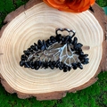 Detailed macro of a silver butterfly hair claw with black natural crystal stones on wood - Obsidian Silver Butterfly