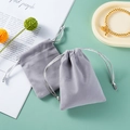 Gray velvet drawstring jewelry pouch with silver cords and elegant gold bracelet display - Drawstring Style - Gray; 5*9cm Velvet Bag