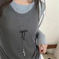 Détail d'un collier argenté avec noeud en velours noir et pendentifs ballerines - 15# Collier-Argent-Noir