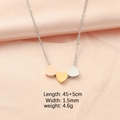 Drei Herzanhänger in Silber, Gold und Roségold auf rosa Seide im Detail präsentiert - Silberne Kette (Gemischte Herzen)