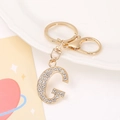 Detail shot of a gold-plated letter G keychain featuring high-quality white rhinestones - Letter G