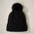 Detalle de gorro de punto negro con pompón y textura gruesa de trenzado - Talla única / Negro