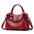Red pebbled leather tote bag with a decorative bow and chunky gunmetal chain detail - Red