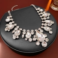 Dettaglio macro della collana geometrica argento con strass scintillanti su supporto - Argento