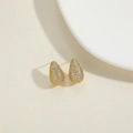 Elegante goldene Tropfenohrringe mit Zirkonia-Pflaster auf einem minimalistischen Hintergrund - Goldene Weiße Zirkonia Tropfenohrstecker