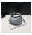 Dettaglio della borsa a mano a pieghe blu-grigio con fibbia dorata e texture denim - Blu