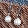 Klassieke witte pareloorbellen met zilveren haken op een bruine getextureerde achtergrond - Witte Parel Haken Oorbellen (6mm)