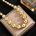 Minimalist gold ball bead necklace with large polished spherical charms on a leather box - Exaggerated Transfer Bead Necklace / Gold