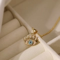 Goldene 18K vergoldete Evil Eye Halskette mit Türkisstein in einer beigen Schmuckbox - Halskette