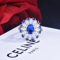 Macro shot of 2ct blue oval gemstone ring with floral diamond halo and silver band - Blue Zirconia / Adjustable Open