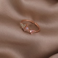 Dettaglio anello fiore oro rosa con pietra cuore rosa su sfondo di seta marrone - Farfalla in Strass Rosa (Oro Rosa) (21699A)