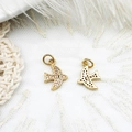 Detailed close-up of gold swallow pendants with micro-pave cubic zirconia on lace - Bird
