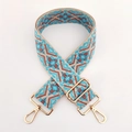 Close-up of wide ethnic jacquard strap with geometric patterns and gold metal buckles - Bright Blue Pink Khaki Floral