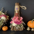 Close-up of decorative straw broom with purple crystal and colorful dried flowers - Broom+Flowers+Amethyst