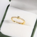 Macro view of a gold-plated brass cross ring with inlaid diamonds in a green jewelry box - Letter X Gold