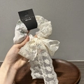 Détail d'un chouchou en dentelle blanche avec broderie florale et long ruban noeud - Style de Ruban / Fleurs Vertes avec Ruban