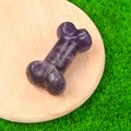 Purple amethyst mini bone sculpture on wood tray with natural grass background - Amethyst