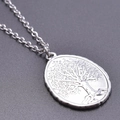 Primer plano de un colgante ovalado de acero inoxidable con grabado del árbol de la vida - Colgante Tono Plateado Con Collar