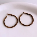Close-up of leopard print hoop earrings in brown and black tones on a white ceramic plate - Round Shape (WE4110) / Coffee Leopard