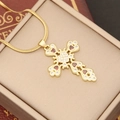 Close-up of 18K gold cross pendant with red heart gems and micro-pave zircons - Red