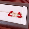 Dettaglio degli orecchini a triangolo rossi con base dorata e cristalli bianchi - Triangolo in Smalto Rosso Con Zirconia / Oro
