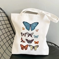 White canvas tote bag featuring vintage colorful butterfly prints on a black metal chair - Colored Butterfly Array-R63