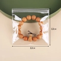 Transparent 12x12cm PVC jewelry sealing bag holding a wooden bead bracelet for storage - 12x12cm/26 Silk Thickness / Clear