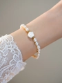 Elegant lavender freshwater pearl bracelet with white rose charm on model's wrist - Pearl Bracelet with White Rose Charm (I-d-014)