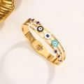 Brazalete vintage de acero dorado con Ojo Turco y cristales de colores sobre fondo blanco - Dorado