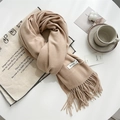 Soft beige pashmina scarf with tassels and brand tag on a cozy autumn tabletop setting - Rice Camel