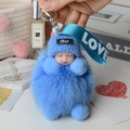 Detailed close-up of a blue fox fur pompom sleeping baby doll keychain for handbags - Sky Blue