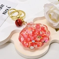 Detailed view of seashell oil-filled keychain with red beads and golden bell charm - Light Gold Buckle + Luminous Shell + Bell / Red