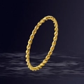 Detailed view of a gold-toned twisted rope ring over a deep blue rippled water background - US 5 / Gold