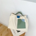 Minimalistische Canvas-Tasche in Creme mit grün-blauen Farbfeldern und Tragegriffen aus Leder - Weiß mit Blau