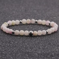Macro shot of 6mm natural pink and white agate beads with polished silver spacers on elastic cord - 6MM Peach Pink