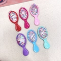 Flat lay of six colorful mini cushion hairbrushes in a variety of vibrant pastel colors - 1 Piece / Solid Color (No Glitter)