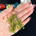 Close-up of translucent green resin gummy bear charms on a metal keychain - Green