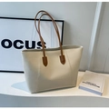 Borsa tote beige minimalista con sottili manici marroni su sfondo bianco con dettaglio - Bianco Sporco