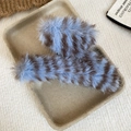 Makro-Detail von flauschigen gestreiften Haarklammern mit weichem blau-braunem Kunstfell - Haarkralle - Blau