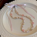 Collier en perles roses et imitation perles avec un ruban sur une assiette blanche - Nœud Rose (80# Collier)