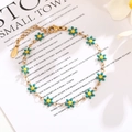Close-up of golden stainless steel chain with teal daisy charms and adjustable lobster clasp - Teal