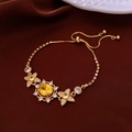 Close-up of gold bracelet with yellow oval stone and star details on red silk - 33# Gold Yellow Gemstone Bracelet