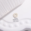 Dettaglio macro di una perla distanziatrice piatta in argento S925 con marchio inciso - Medio 5*5mm / Argento