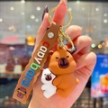 Mignon porte-clés Capybara en silicone marron et blanc avec une sangle de transport - Tenant un Bébé